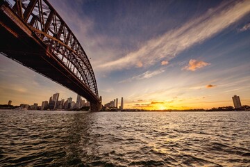 Obraz premium Bridge crossing a body of water at sunset in Sydney, Australia.