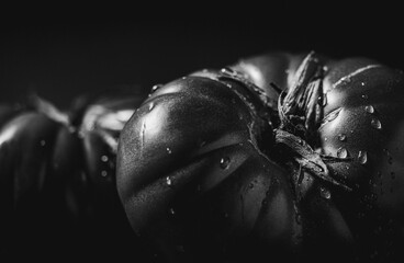 Grayscale shot of two ripe Spanish tomatoes on a solid tabletop, isolated on a blank background