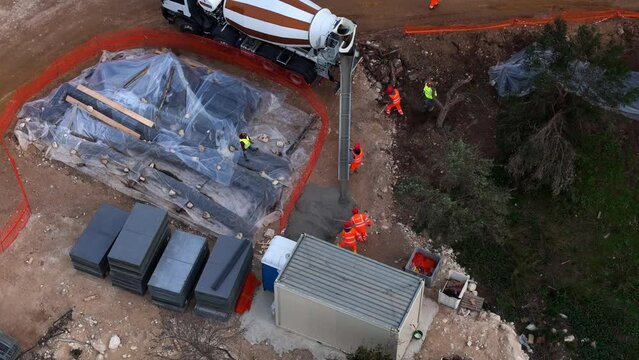 Drone footage of a concrete mixer pouring concrete on a soil in a construction site