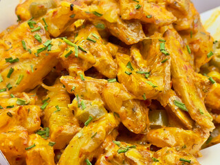 Wicker basket filled with cooked potatoes covered with melted cheese