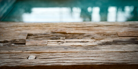 Weathered old wooden texture in front of reflecting water surface. Shabby old wooden surface with...