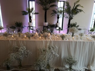 a table has many different tables covered with flowers and candles