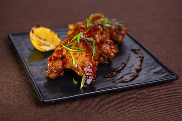 Delicious And Spicy Grilled Chicken Wings With Lemon Garnish