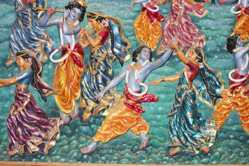 Bas-relief on the wall of the temple. Lord Krishna dances with the Gopis.