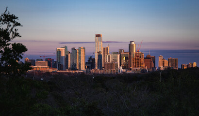 Fototapeta premium Aerial view of the beautiful skyline of Downtown Austin, Texas illuminated by the golden sunset