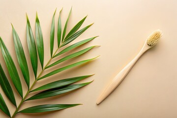 Bamboo toothbrush and green palm leaf on beige background.