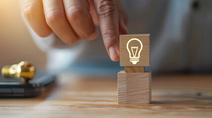 Man moves wooden cube with picture of glowing light bulb. Concept of idea emergence and selection - Powered by Adobe