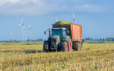 Traktor und Maishäcksler während der Maisernte 