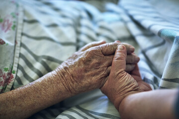 Senior person, hands and visit with hospital, closeup and pensioner care or love together. Elderly...