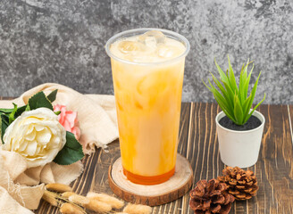 Passion Fruit Yakult iced tea with ice cube served in disposable glass isolated n table side view...