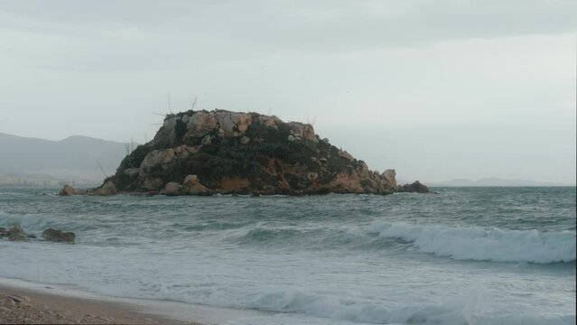 Rocky island surrounded by ocean sea. Peaceful sea scene with calm waves.  Perfect for peaceful, calming visuals, and relaxation videos. Visual for Meditation and Yoga Backgrounds