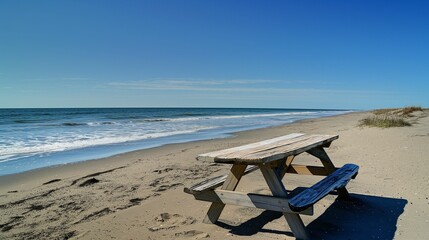 Fototapeta na wymiar Wooden picnic table on sandy beach with ocean view.