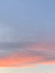 Beautiful sunset sky with pastel pink and blue hues. Soft clouds create a soothing and peaceful atmosphere, capturing the tranquility of the evening