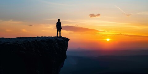 Fototapeta premium The man standing on the cliff watching the sunset.