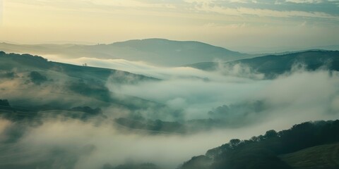 Obraz premium The morning fog gently embraces the hills, creating a mystical and serene landscape.