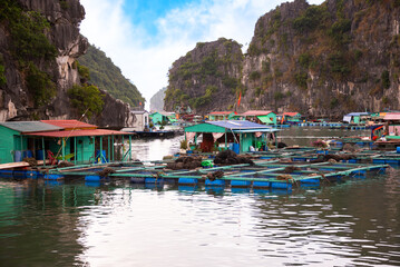 Floating fishing village in sea bay in Vietnam, boats and islands © Maresol