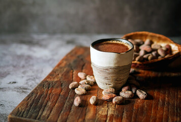 Natural craft cocoa drink on wooden tray, organic healthy chocolate drink with brown cocoa beans...