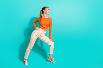 Full size photo of positive girl with ginger hair dressed orange shirt look at promo empty space...