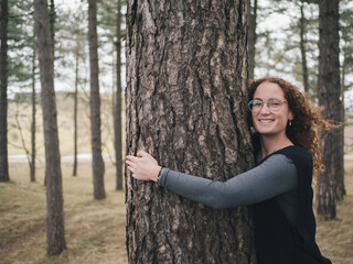 Joyful Woman Hugging Tree in Forest