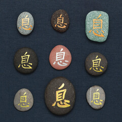 Chinese character xi or Japanese iki, meaning rest, written on pebble