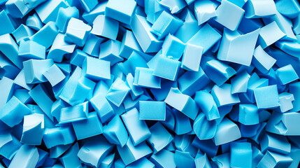 A close-up of a pile of blue foam pieces, resembling offcuts or fragments, showcasing different shapes and textures.