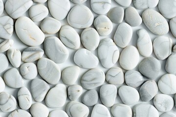 Round white flat beach pebbles laying on white background, up view photo