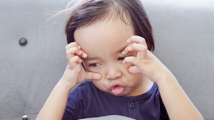 cute Asian toddler on the couch and making funny face