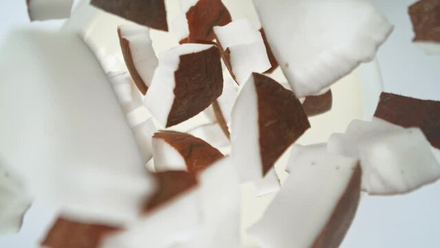 Super Slow Motion of Falling Coconut Pieces into Cream. Filmed on High Speed Cinema Camera, 1000fps, Placed on High Speed Cine Bot. Camera in Motion, Following Objects.