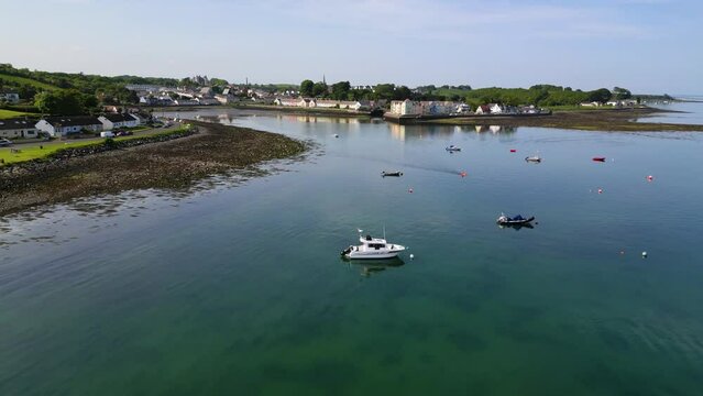 Drone shot flying over boats moored at sea to a picturesque village, Killyleagh, County Down, Northern Ireland, United Kingdom, UK