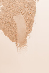 swatche of cosmetic structure powder powder in natural beige tone. Top view. Beige vertical background. Layout. Sample. Template. A copy space.