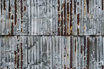weathered corrugated metal sheets with a distinct, rough texture and pattern.