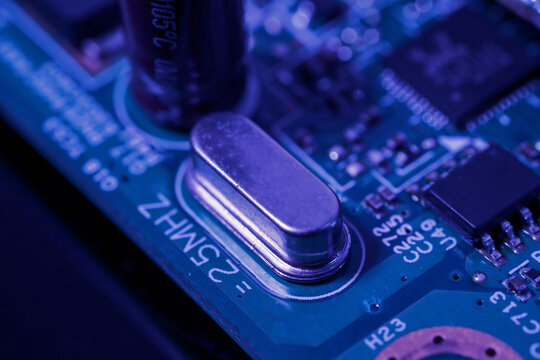 Green circuit board with various electronic components.