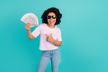 Photo portrait of lovely young lady hold point money fan dressed stylish striped garment isolated on aquamarine color background