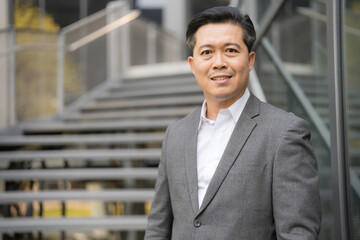 Confident businessman standing outdoors by staircase