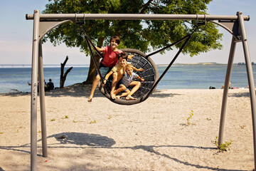 Children on beach swing. Kid swinging in Malmo, Sweden, travel with young children. Summer family...