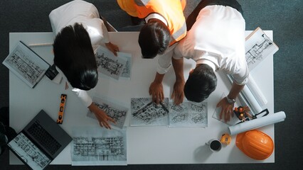 Top down view of project manager and civil engineer hold laptop while explain idea to architect....