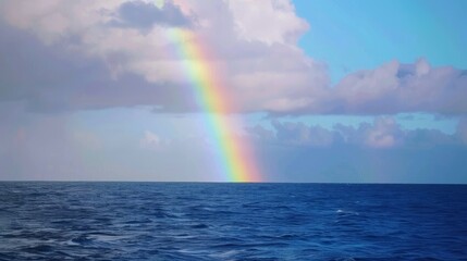 Vibrant rainbow spanning the sky above calm sea with soft clouds, representing peace and tranquility