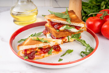 Grilled Pizza Sandwich, cheese pizza burger with tomatoes, tomato sauce, bacon, pepperoni salami, arugula, copy space