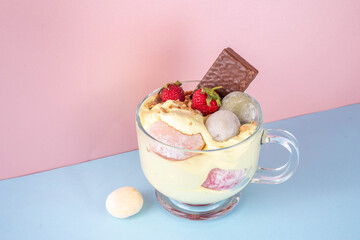 Mochi parfait trendy asian dessert, ice cream parfait layered with fruit, berry, sweets and various mochi. Summer frozen sweet snack in portioned cup, copy space