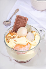 Mochi parfait trendy asian dessert, ice cream parfait layered with fruit, berry, sweets and various mochi. Summer frozen sweet snack in portioned cup, copy space