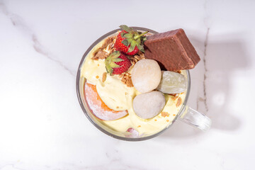 Mochi parfait trendy asian dessert, ice cream parfait layered with fruit, berry, sweets and various mochi. Summer frozen sweet snack in portioned cup, copy space
