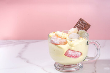 Mochi parfait trendy asian dessert, ice cream parfait layered with fruit, berry, sweets and various mochi. Summer frozen sweet snack in portioned cup, copy space