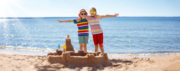 Boy and girl building on the beach sandcastle. Family vacation and tourism concept.