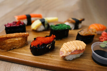 Sushi platter. A selection of raw fish and rice snacks on wooden surface.
