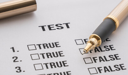 test answer sheet with two items: false or true. Test answer sheet and pen on the desk