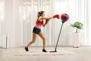 Full length profile shot of a young woman training box