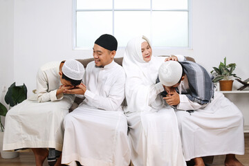 Asian Moslem children beg for forgiveness to their parents during Eid Mubarak moment
