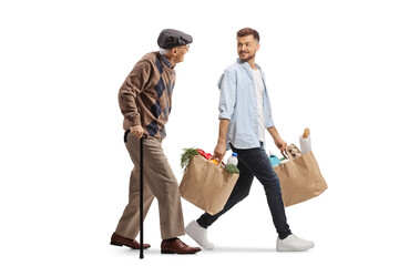 Young man carrying grocery bags and talking to an elderly man