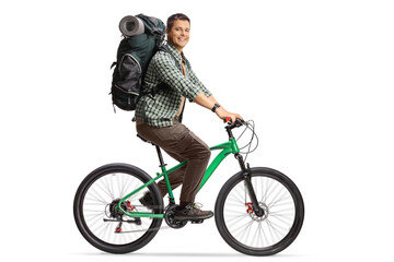 Full length profile shot of a young man with a backpack riding a bicycle and smiling