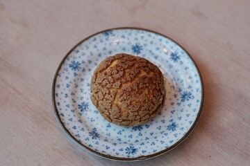 A choux cream puff bakery pastry on the plate.
